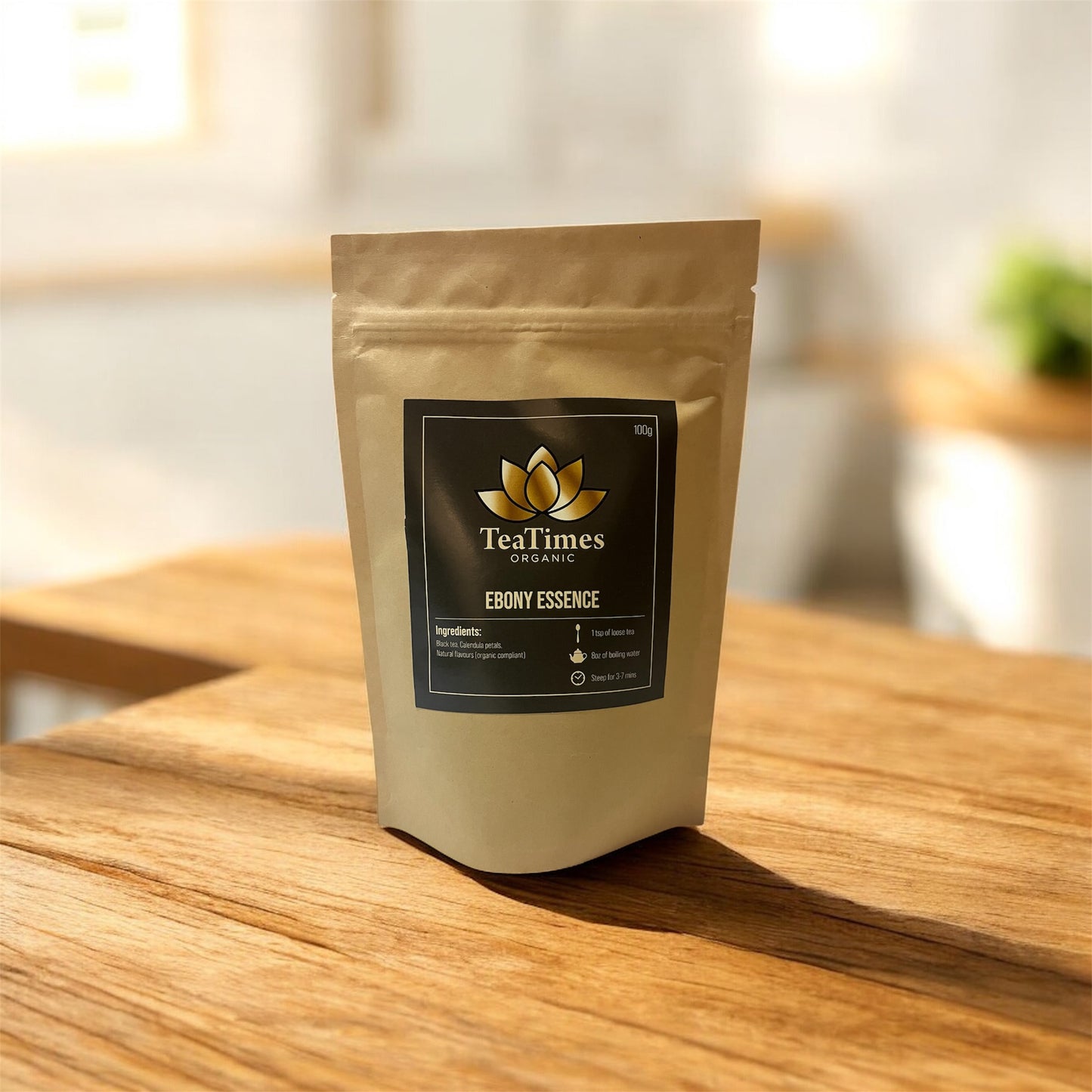 TeaTimes Organic Ebony Essence tea package on a wooden surface with a blurred background