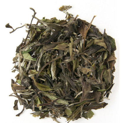 A pile of dry white tea leaves with a green and slightly withered appearance.