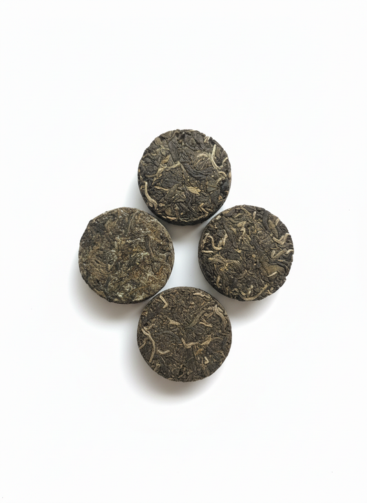 Four dark brown tea leaves on a white background