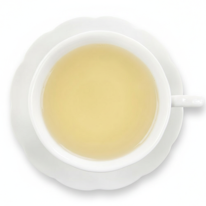 White cup and saucer with a light yellow liquid on a white background